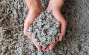two hands holding a pile of cellulose insulation
